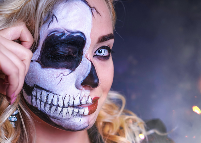 Woman with half-skull Halloween face makeup for Bonvital Hotel's Halloween weekend