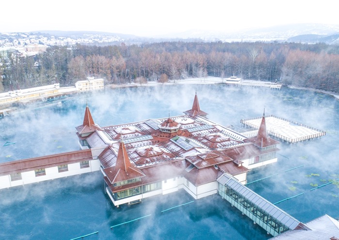 Aerial view of steaming Lake Hévíz in a snowy winter landscape